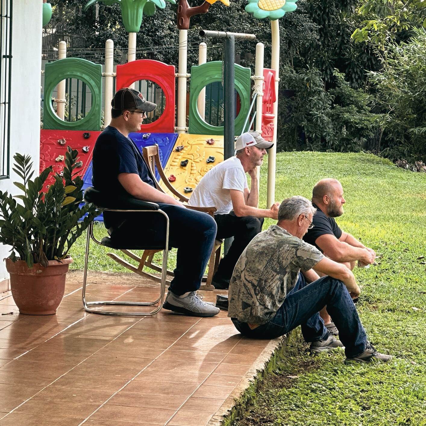 a group of men sitting on a porch
