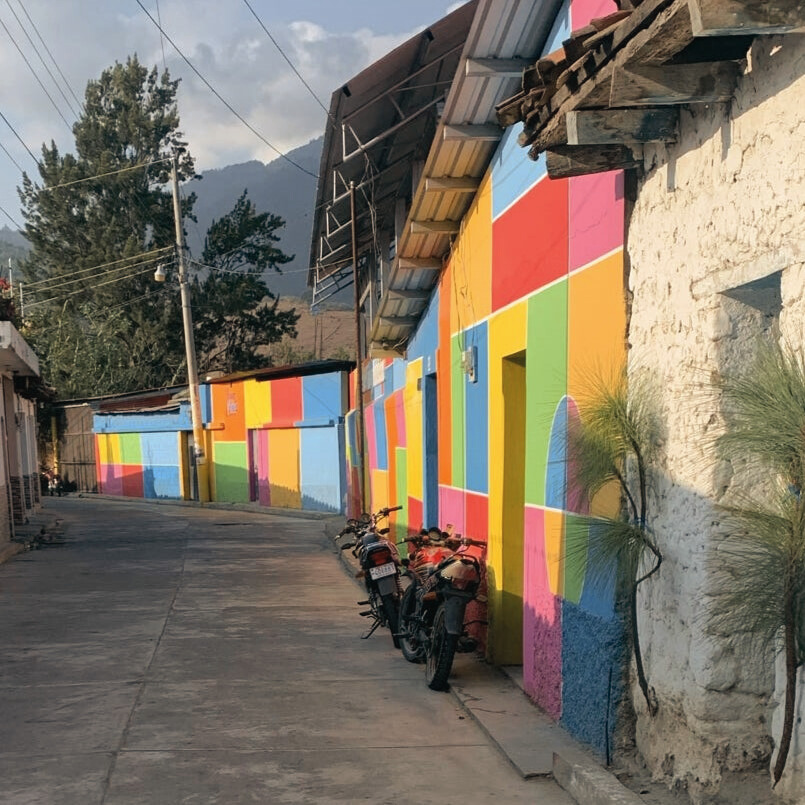 a row of motorcycles parked in front of a colorful building
